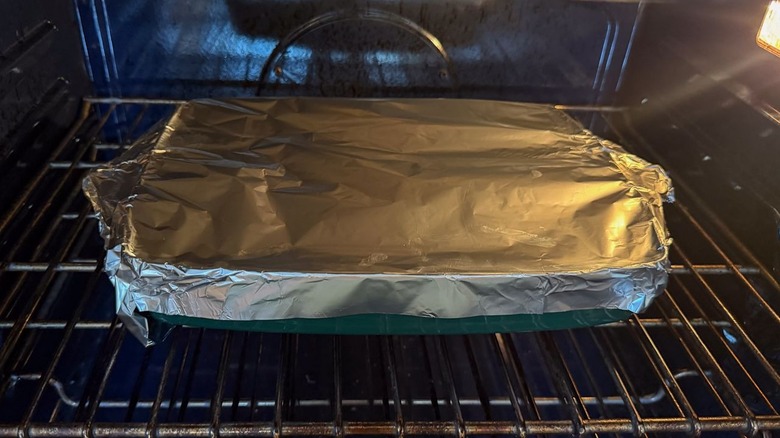Baking dish covered with foil in oven