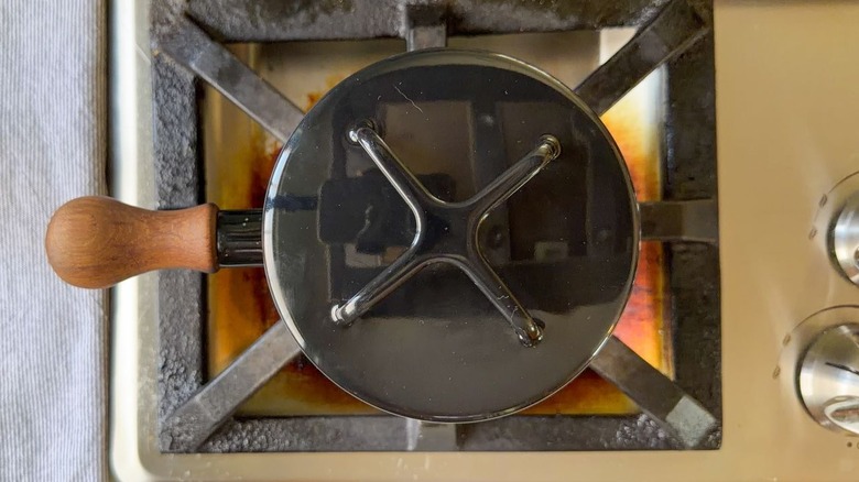 Small black covered pot on stovetop