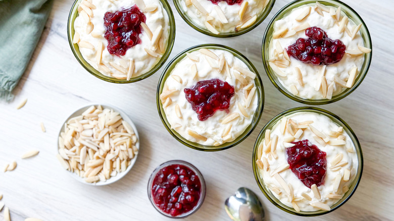 Swedish-style rice pudding in serving cups with lingonberries and sliced almonds