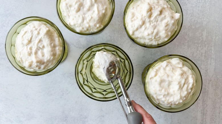 Scooping Swedish-style rice pudding into serving bowls