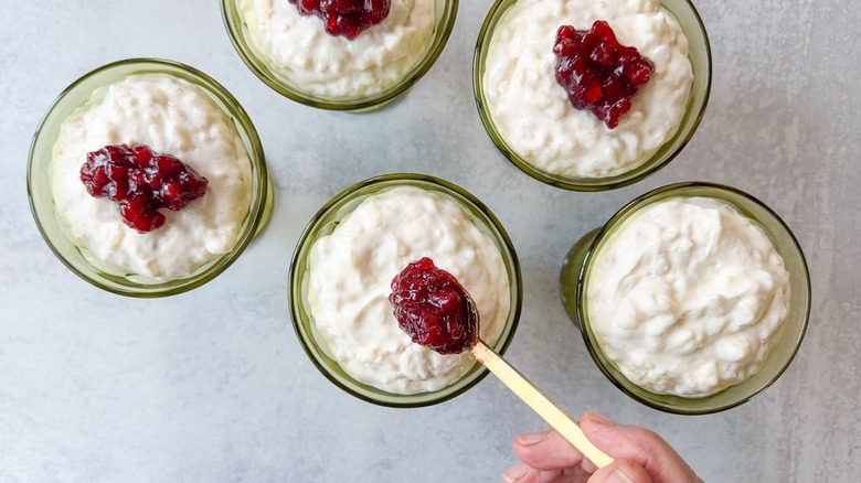 Spooning lingonberry sauce onto Swedish-style rice pudding