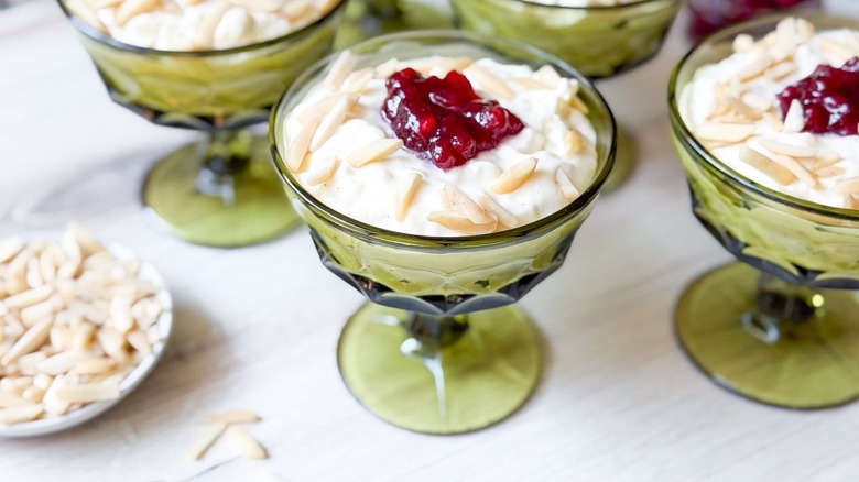 Swedish-style rice pudding in serving glasses with lingonberries and sliced almonds