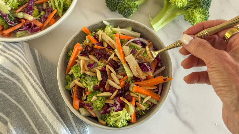 hand with fork in broccoli slaw