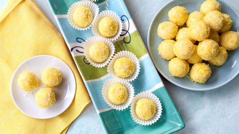 Lemon truffles in paper casings on platter and on serving plates