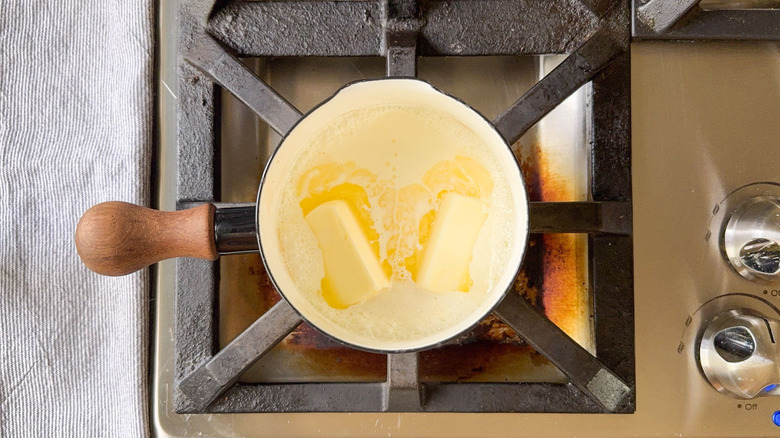 Heavy cream and butter heating in saucepan on stovetop