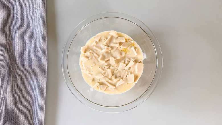 Hot cream and white chocolate in glass bowl