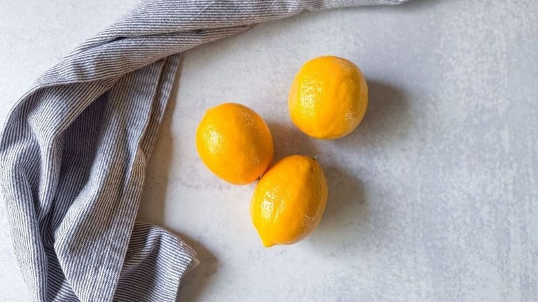 Meyer lemons on countertop with dish towel
