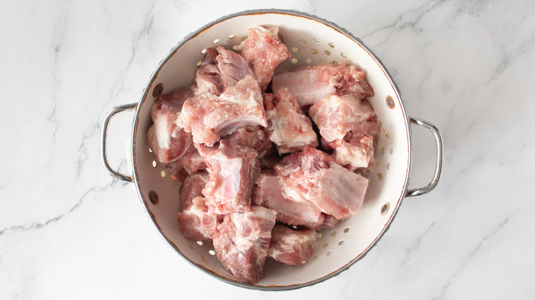 Pork riblets in colander