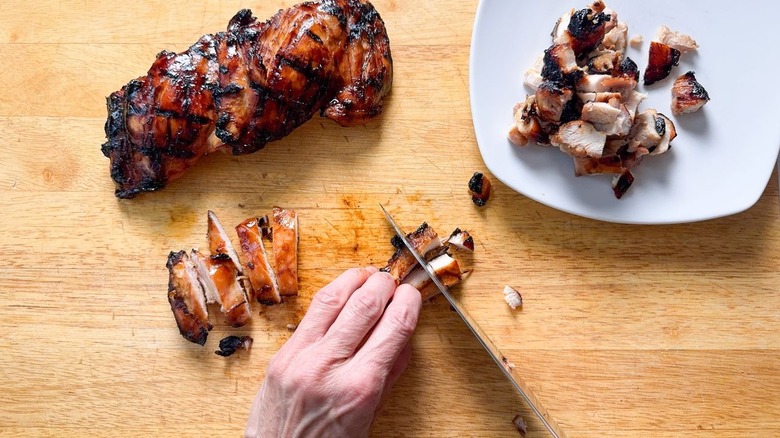 Cutting grilled chicken thighs into pieces