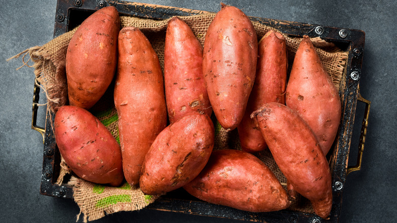 A rustic box filled with sweet potatoes