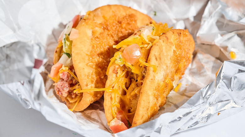 Two chicken bacon ranch chalupas resting on foil packaging.