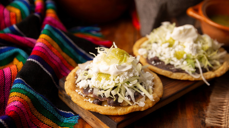 Chalupas with toppings on a wooden board