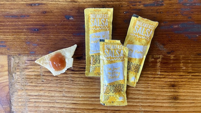 Packets of Taco Bell Breakfast Salsa with a dollop on a tortilla chip