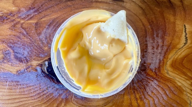Tortilla chip in ramekin of Taco Bell Nacho Cheese Sauce