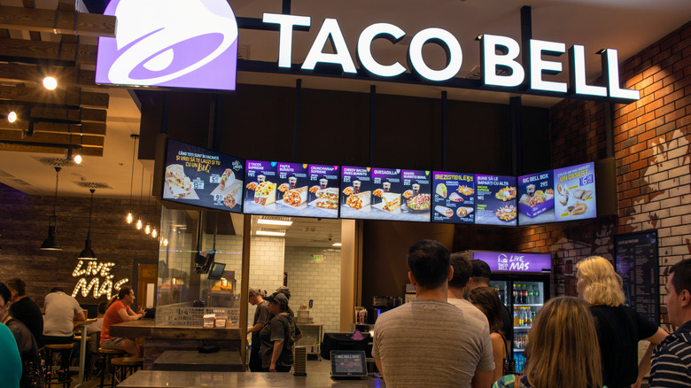 Customers wait in line to order at a Taco Bell restaurant