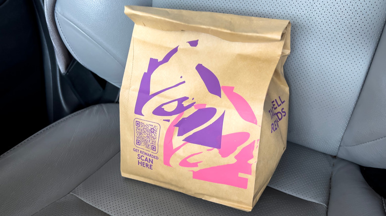 Taco Bell bag sitting on the seat of a car
