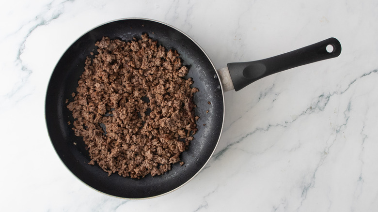 A large nonstick skillet filled with cooked and seasoned ground beef