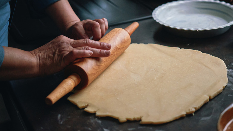 hands rolling out pie crust