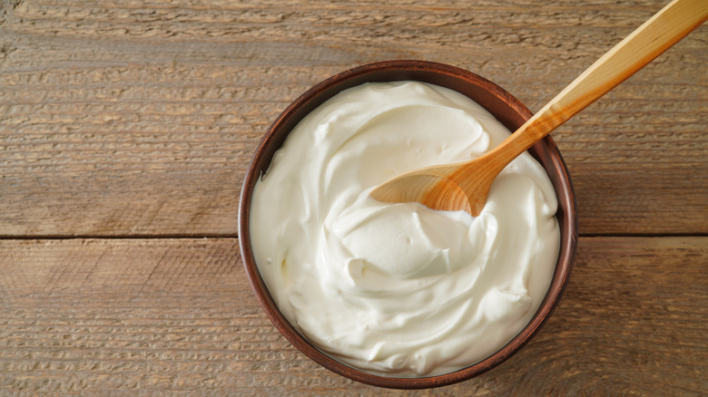 sour cream in a bowl with a wooden spoon