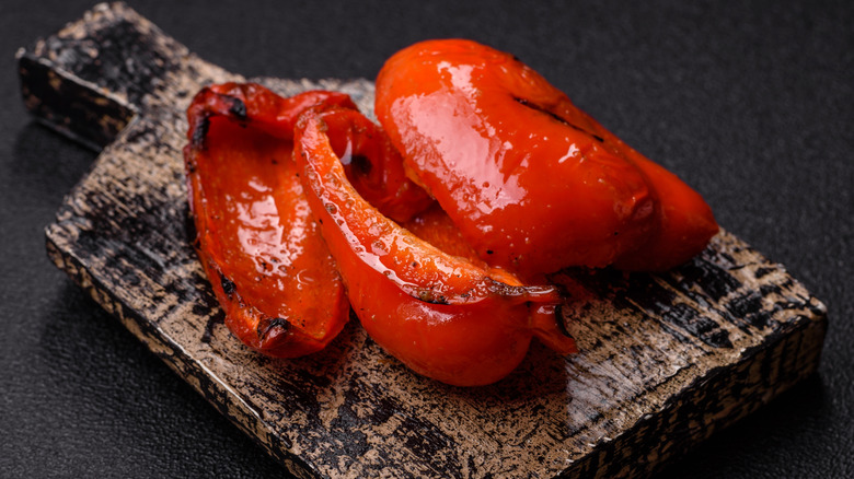 Roasted red peppers on a wooden board