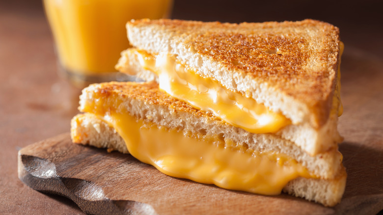Sliced grilled cheese on a wooden board