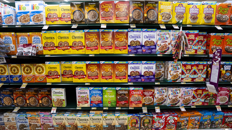 The cereal aisle of a supermarket showing many different brands and flavors of cereals