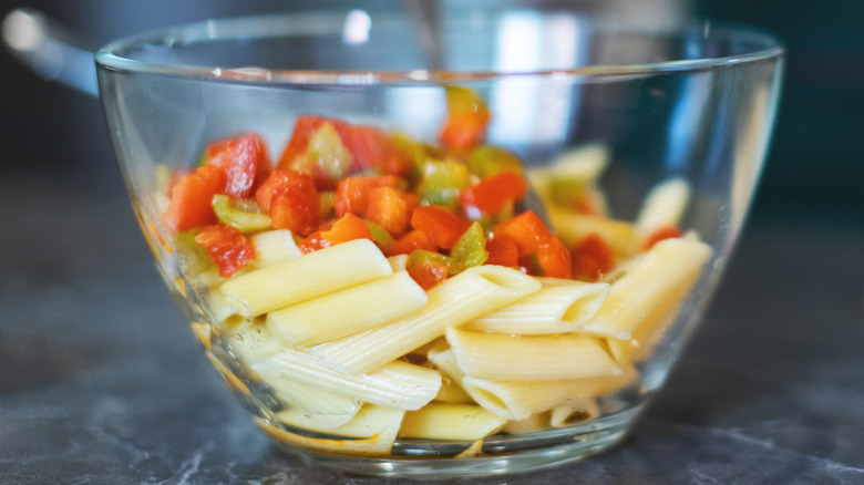 Close-up of chilled cooked pasta and other ingredients in a glass bowl