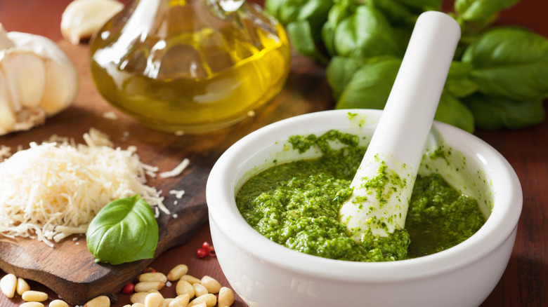 fresh pesto sauce in white mortar and pestle