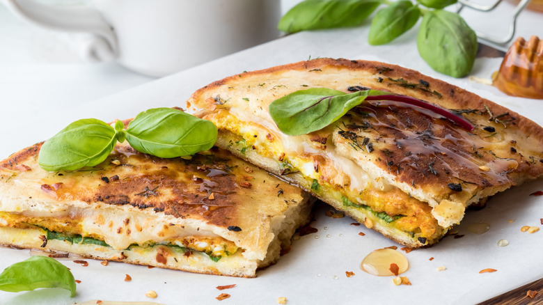 naan bread sandwich with basil and crushed red pepper flakes on top