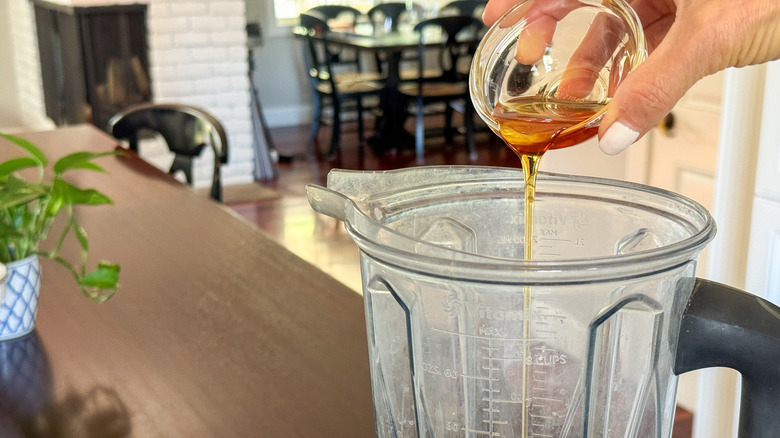 hand adding agave to blender