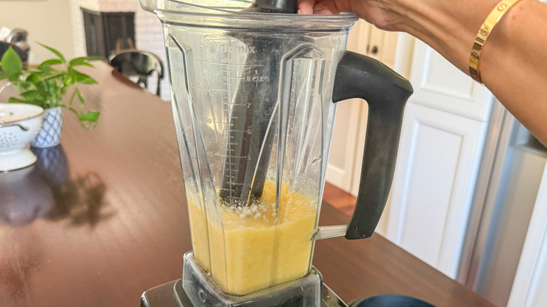 hand using tamper in blender