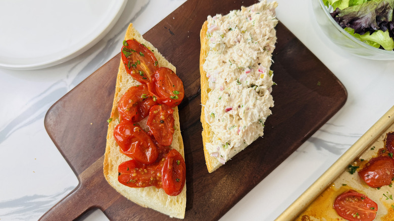 Tuna salad sandwiches being assembled on a cutting board