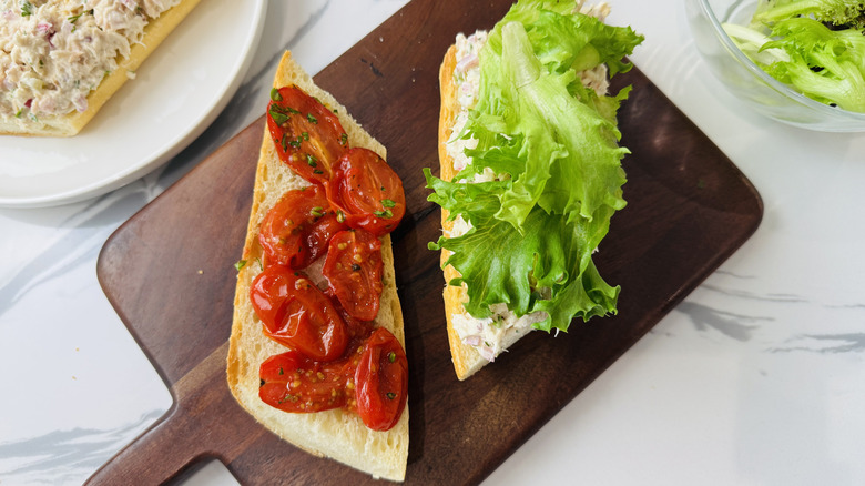 Opened tuna salad sandwiches with grape tomatoes and lettuce on top