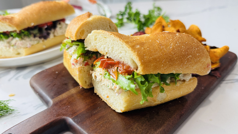 Assembled tuna salad sandwiches on cutting board and plate