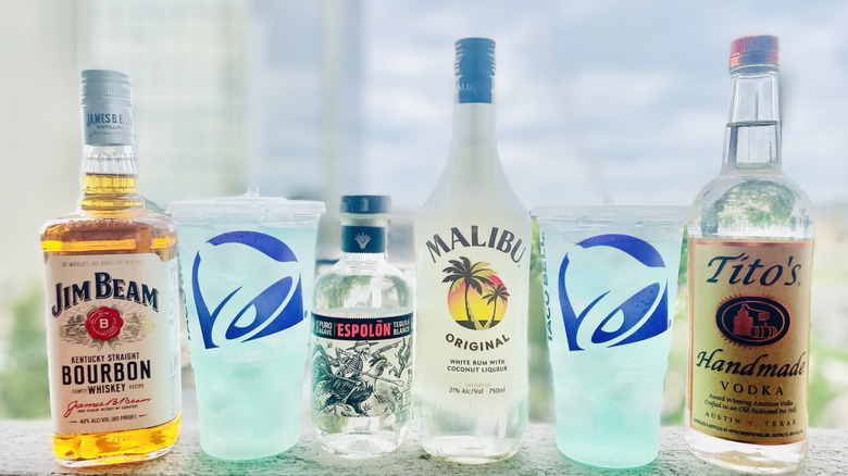 Various bottles of liquor with large Baja Blast sodas form Taco Bell