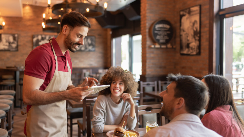 Waiter taking an order from a table of three in a restaurant
