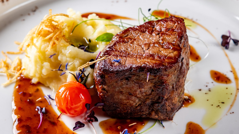 Grilled filet mignon with mashed potatoes and sauce on plate