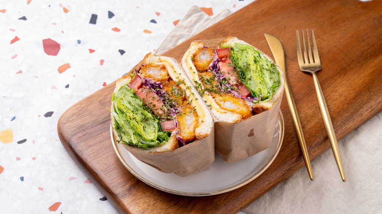 Top angle view of teriyaki chicken sandwich with vegetables wrapped in paper
