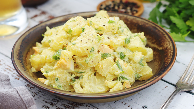 A wooden bowl of potato salad.