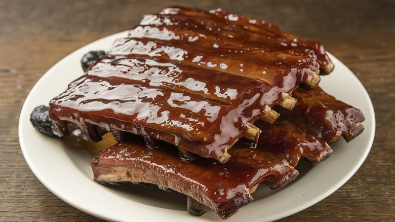 Well sauced BBQ ribs served on a white plate