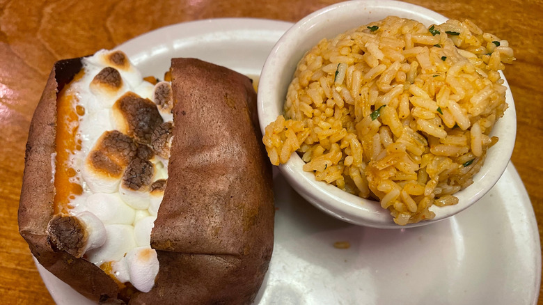A side of baked sweet potato with marshmallows and seasoned rice at Texas Roadhouse