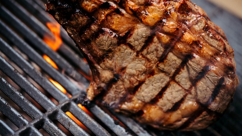 new york strip steak cooking on a grill