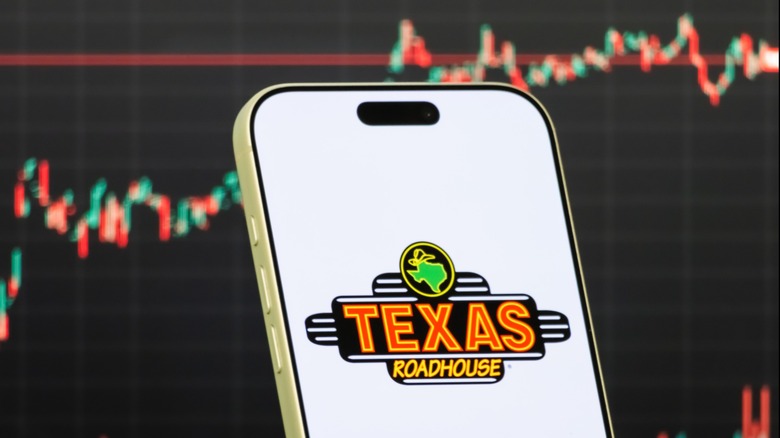 Texas Roadhouse logo in front of the company's positive stock performance graph.