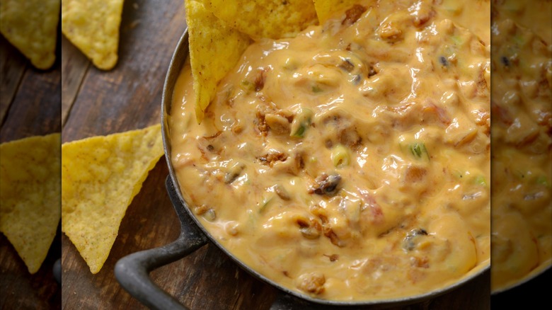 Cast iron skillet of cheese dip with tortilla chips