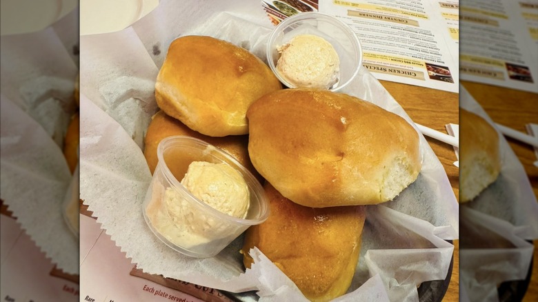 Texas Roadhouse rolls with cinnamon hone butter on a table with menus