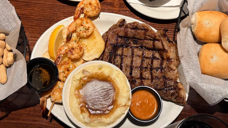 A steak with rolls and various sides at Texas Roadhouse