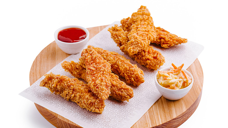 Chicken tenders on wooden board