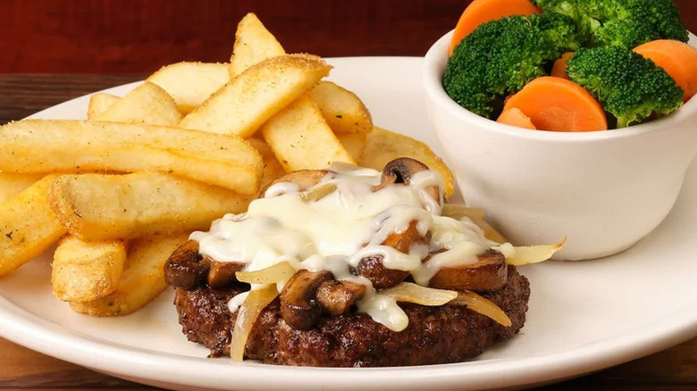 Texas Roadhouse Roadkill steak served with baked potato on a white plate