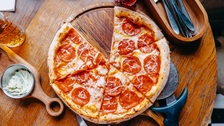 top down view of pepperoni pizza with utensils