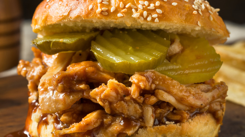 close-up of shredded chicken sandwich with pickles